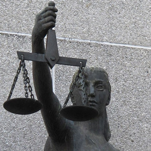Photograph of woman holding the scales of justice symbol